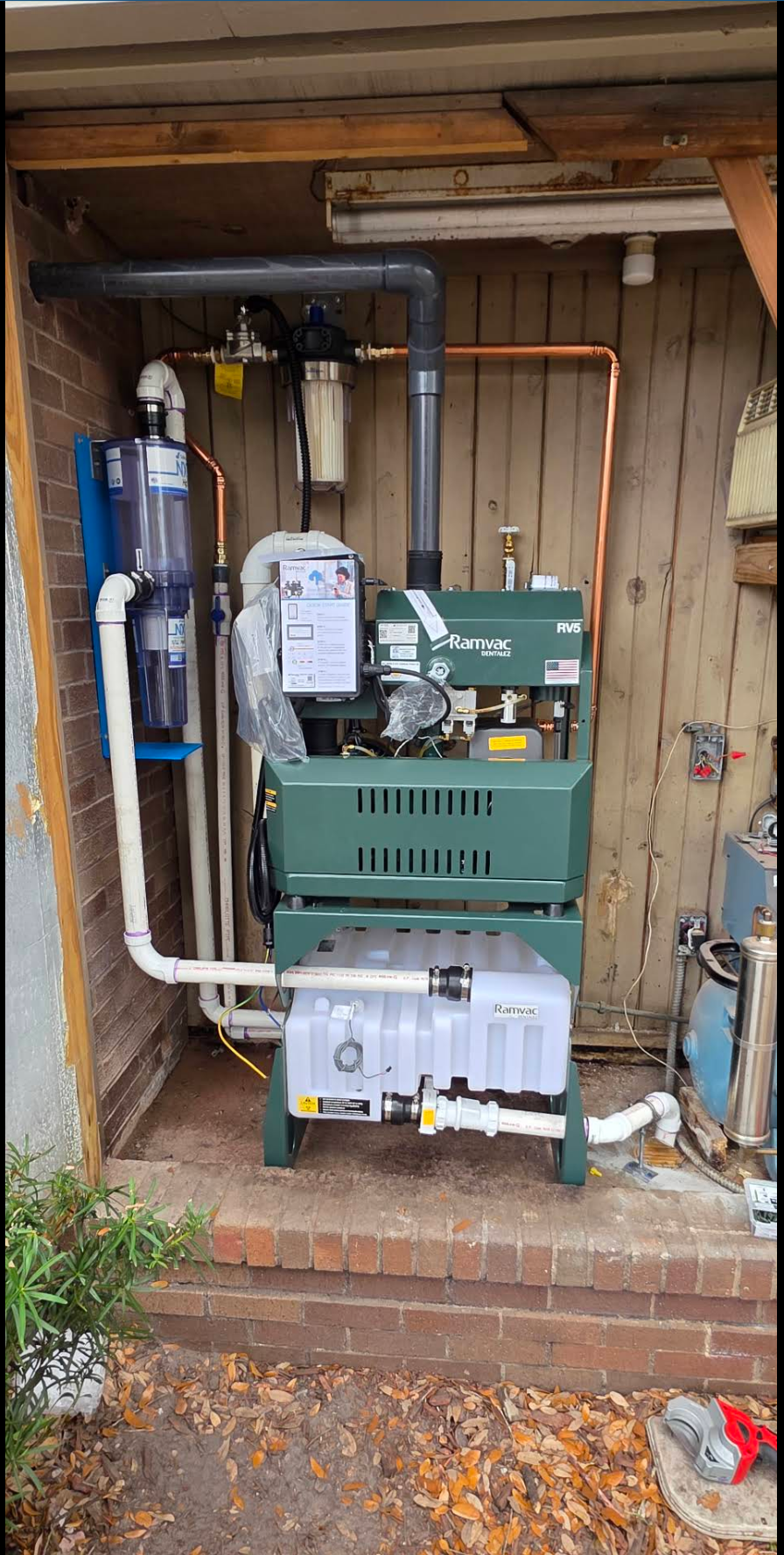 Dental office vacuum pump and filtration system installed outdoors with new copper, PVC drain piping and shutoff valves