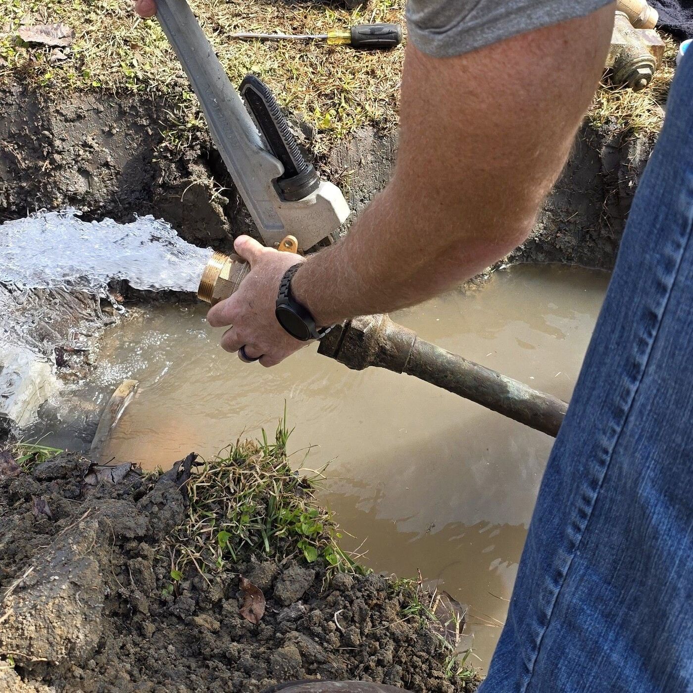 Plumber replacing a leaking main water line at the meter, stopping water loss and restoring full pressure to the house